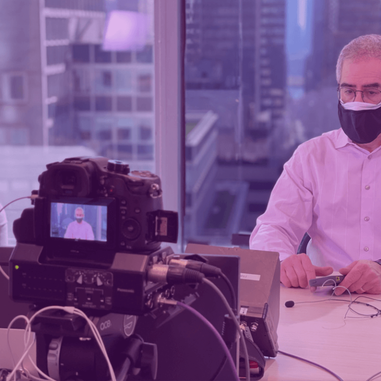 behind the scene live streaming camera with masked speaker in focus