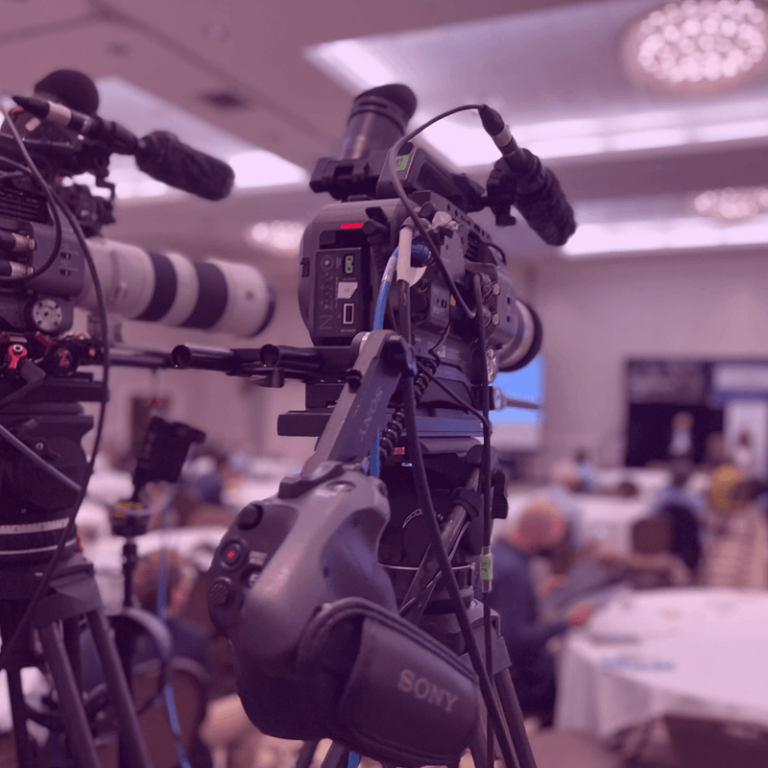 camera equipment behind the crowd of an ongoing corporate event production
