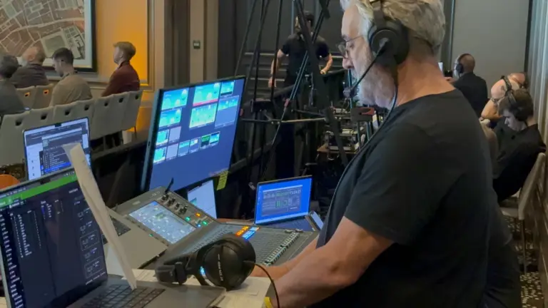 Crew on headset at the show desk during a live general session.