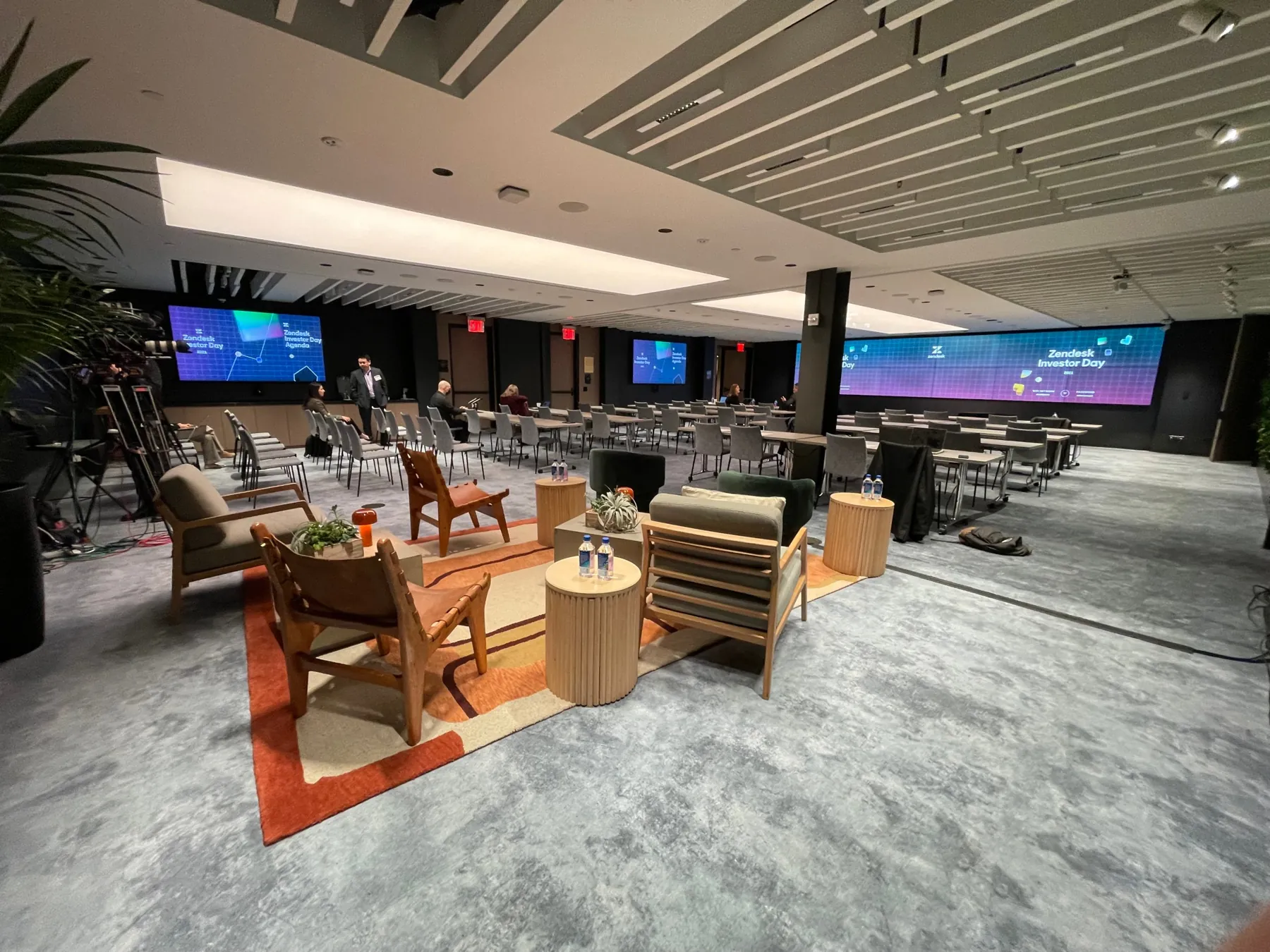 The Zendesk Investor Day room before doors: a lounge area up front, classroom seating and a wide LED wall.