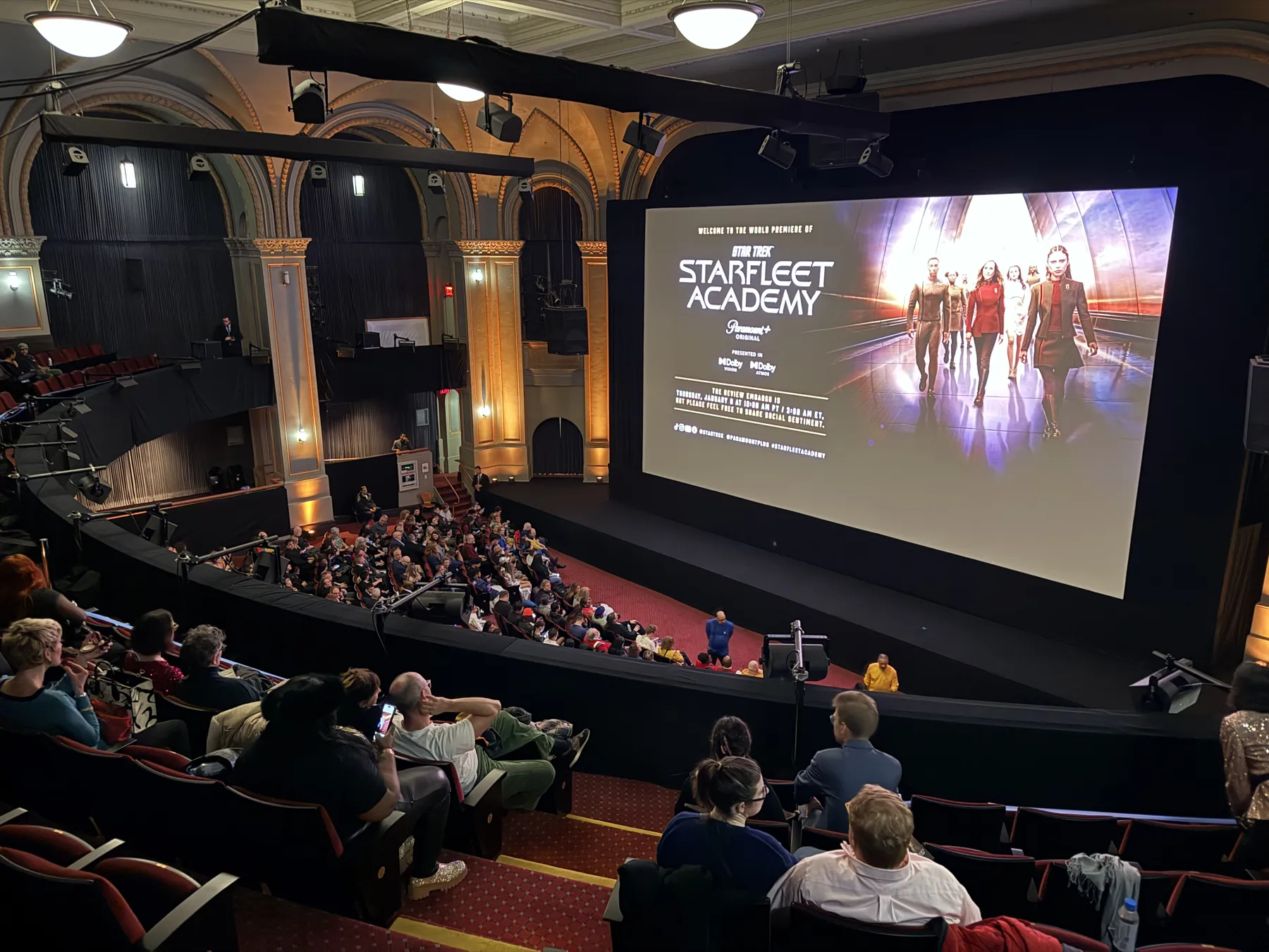 A full historic theater seen from the balcony, with a Star Trek: Starfleet Academy image on the big screen.